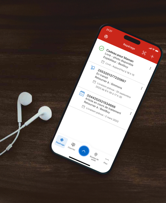 Un cellulaire est utilisé pour suivre des envois dans l’appli de Postes Canada. Des écouteurs sont posés à côté du cellulaire