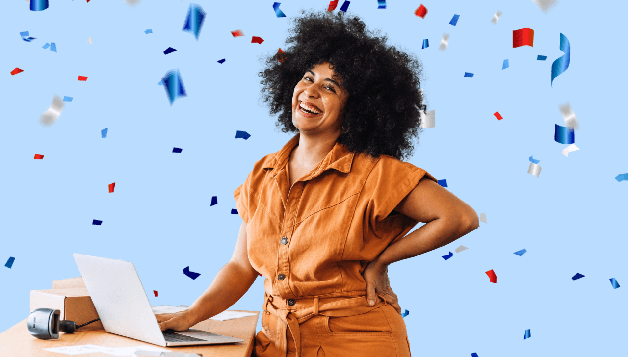 Une femme tout sourire vêtue d’une blouse orange manipule le clavier de son ordinateur portable à côté duquel se trouvent un colis et un balayeur optique.